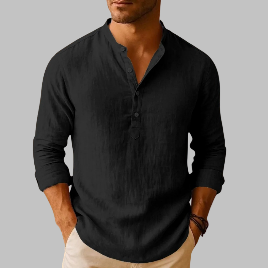 Man wearing a black long-sleeve shirt against a gray background